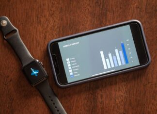 Sportowe technologie noszone a prywatność: jak mądrze udostępniać dane o zdrowiu Smartfon i smartwatch z tygodniowym raportem zdrowia na drewnianym stole
