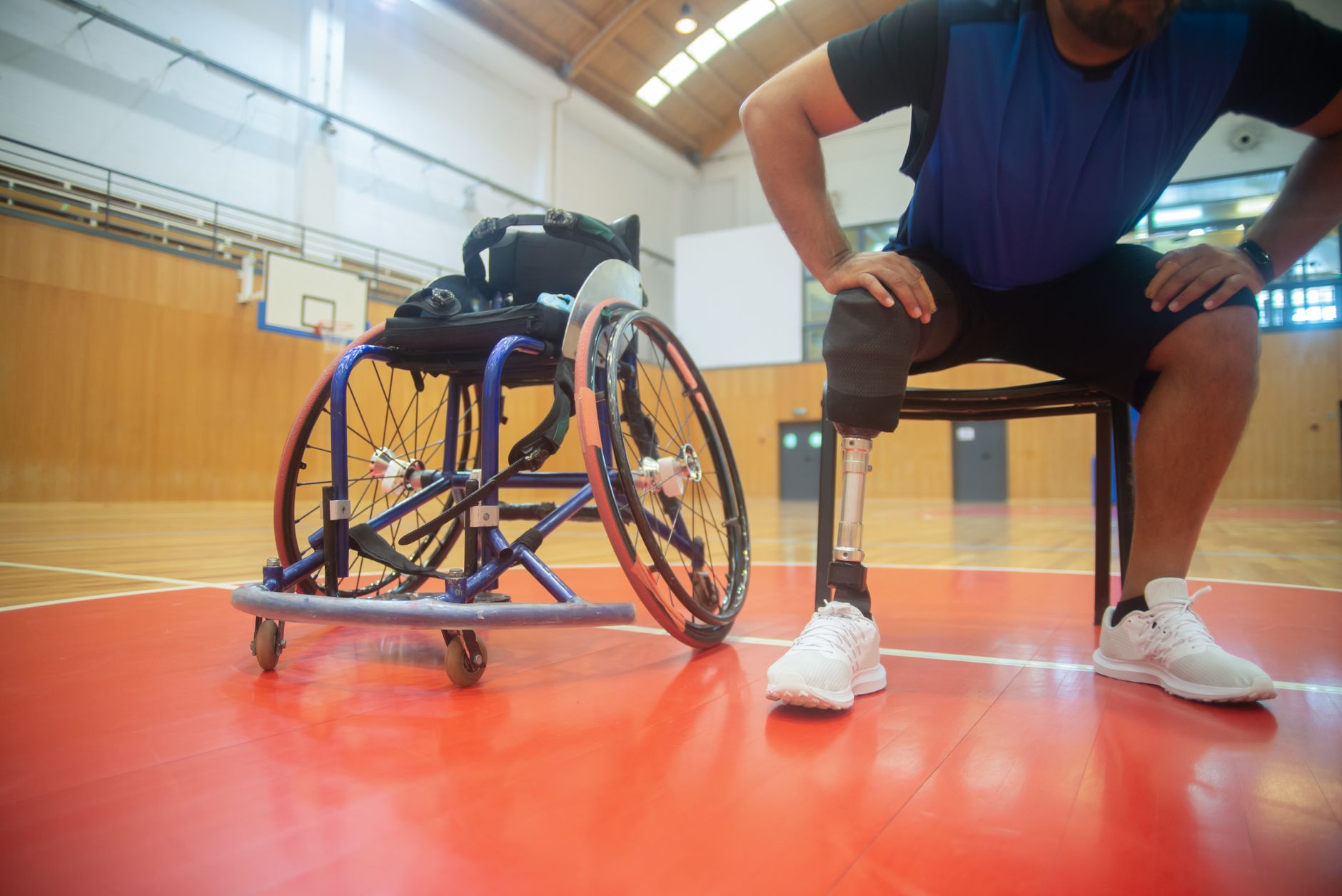 Zawodnik z protezą nogi odpoczywa na hali sportowej