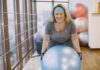 Twój pierwszy trening grupowy: jak przełamać nieśmiałość i odnaleźć się w sportowej społeczności Kobieta ćwicząca na piłce fitness w grupowej sali treningowej