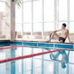 Sportowiec po amputacji odpoczywa przy basenie na pływalni krytej