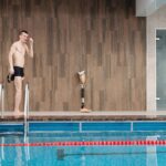Sportowiec z protezą nogi przy krytym basenie
