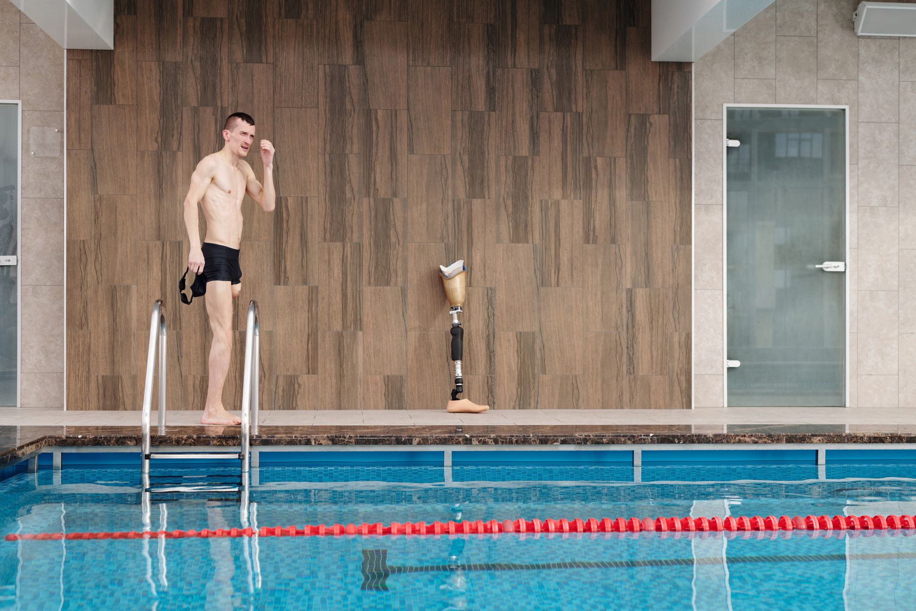 Sportowiec z protezą nogi przy krytym basenie