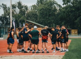 Uczniowski klub sportowy czy stowarzyszenie zwykłe: co wybrać dla małej sekcji sportowej? Młodzi sportowcy podczas treningu na bieżni lekkoatletycznej