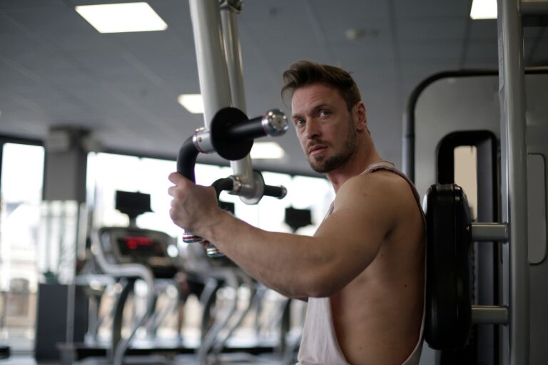 Skupiony mężczyzna ćwiczący biceps na siłowni