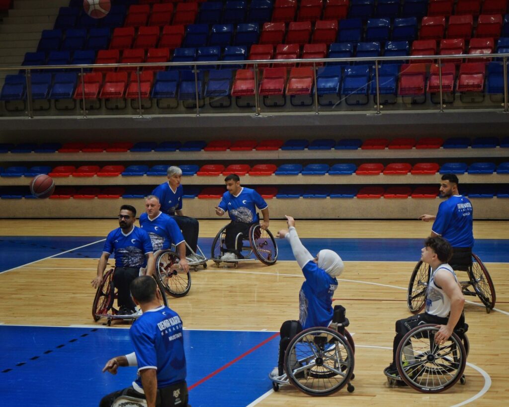 Zawodnicy koszykówki na wózkach podczas meczu w hali sportowej